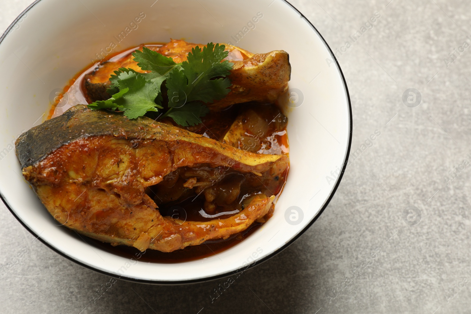 Photo of Tasty fish curry on light grey table, closeup. Space for text. Indian cuisine