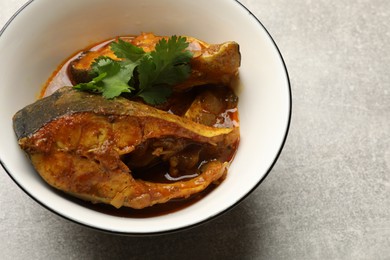 Photo of Tasty fish curry on light grey table, closeup. Space for text. Indian cuisine