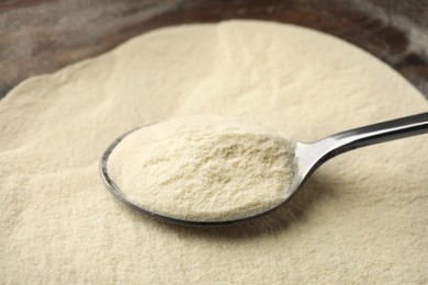 Photo of Organic agar-agar powder and spoon on table, closeup