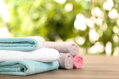 Photo of Clean towels on table against blurred background. Space for text