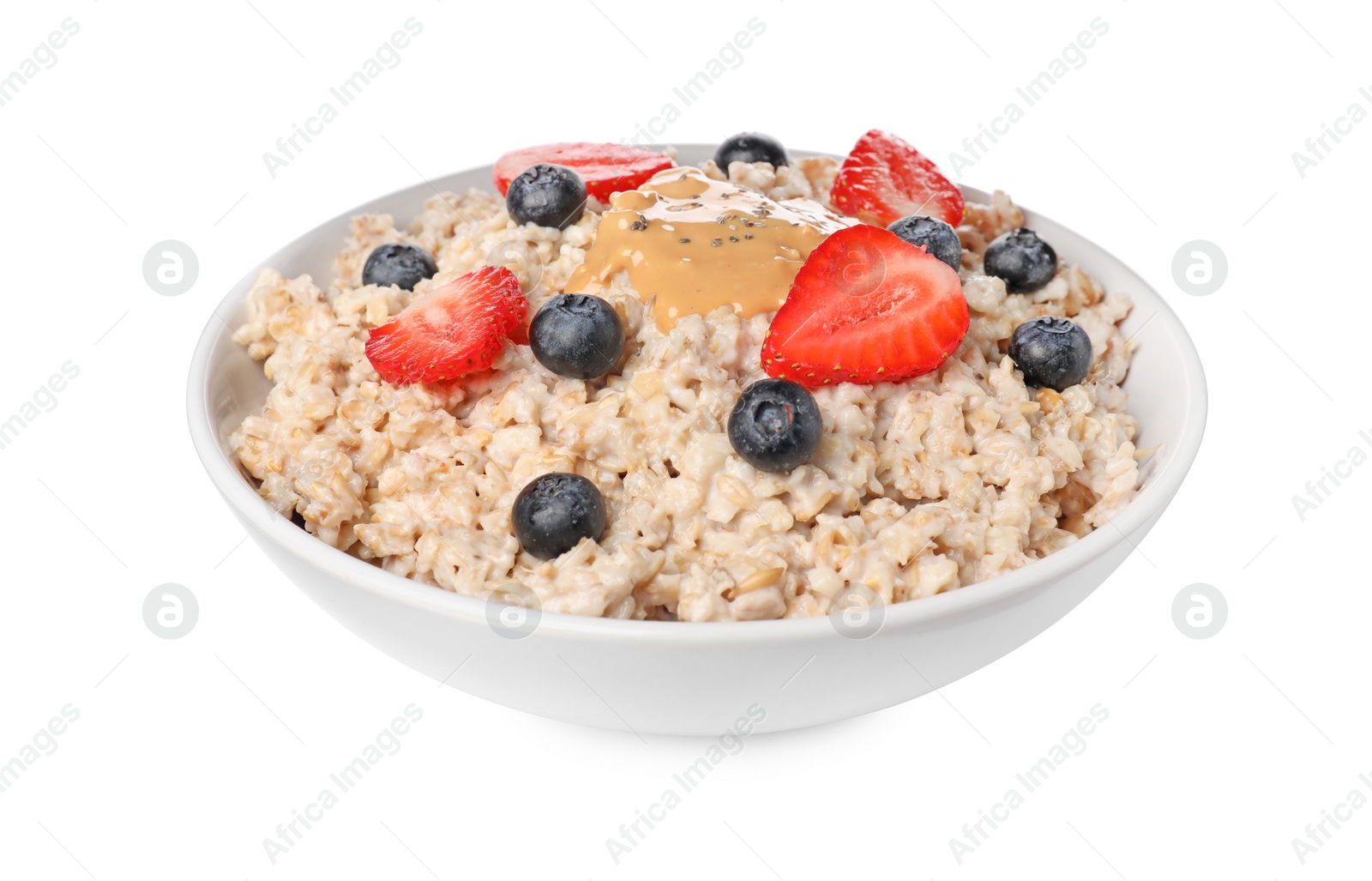 Photo of Tasty boiled oatmeal with berries, peanut butter and chia seeds in bowl isolated on white