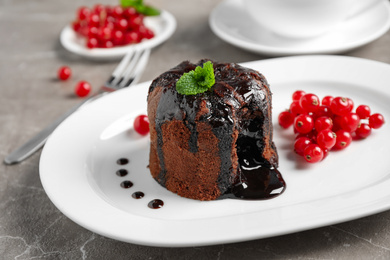 Delicious warm chocolate lava cake with mint and berries on marble table, closeup