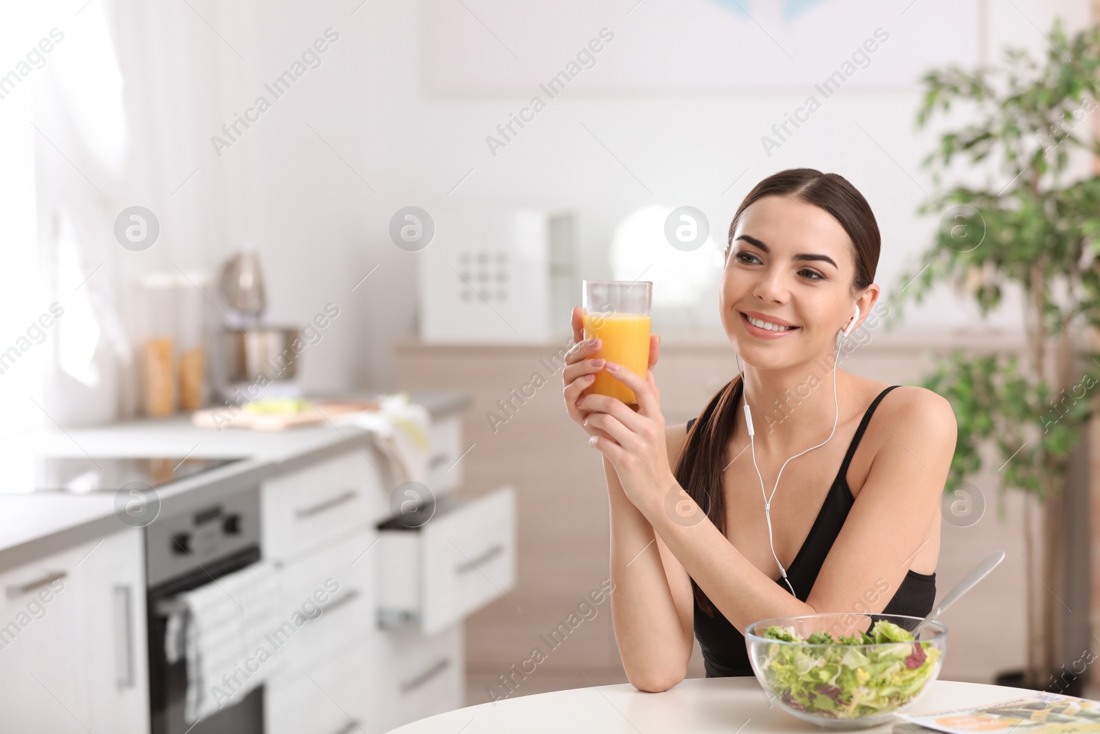 Photo of Young woman in fitness clothes having healthy breakfast at home. Space for text