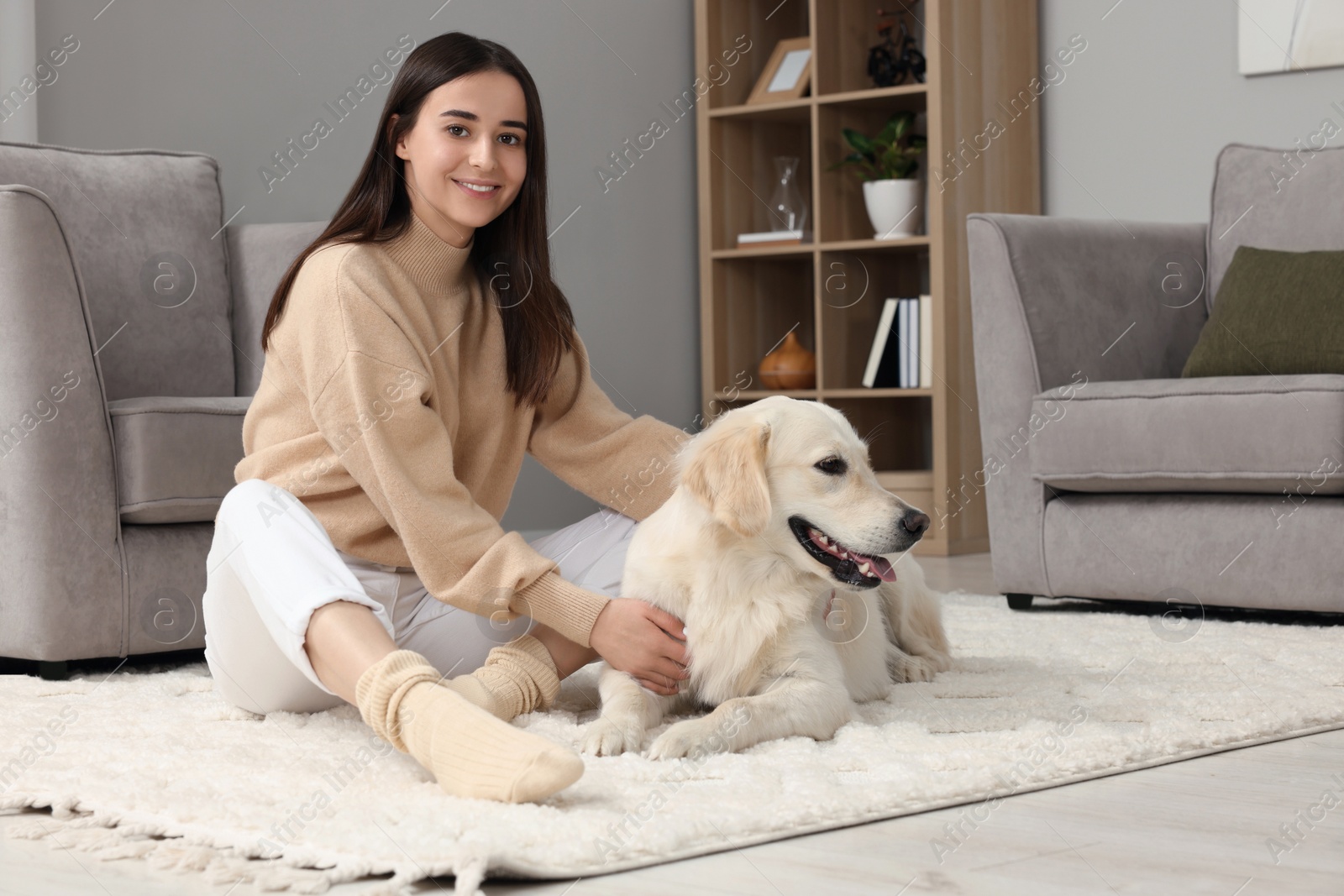 Photo of Happy woman with cute Labrador Retriever dog on floor at home. Adorable pet