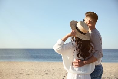 Young couple on beach near sea. Honeymoon trip