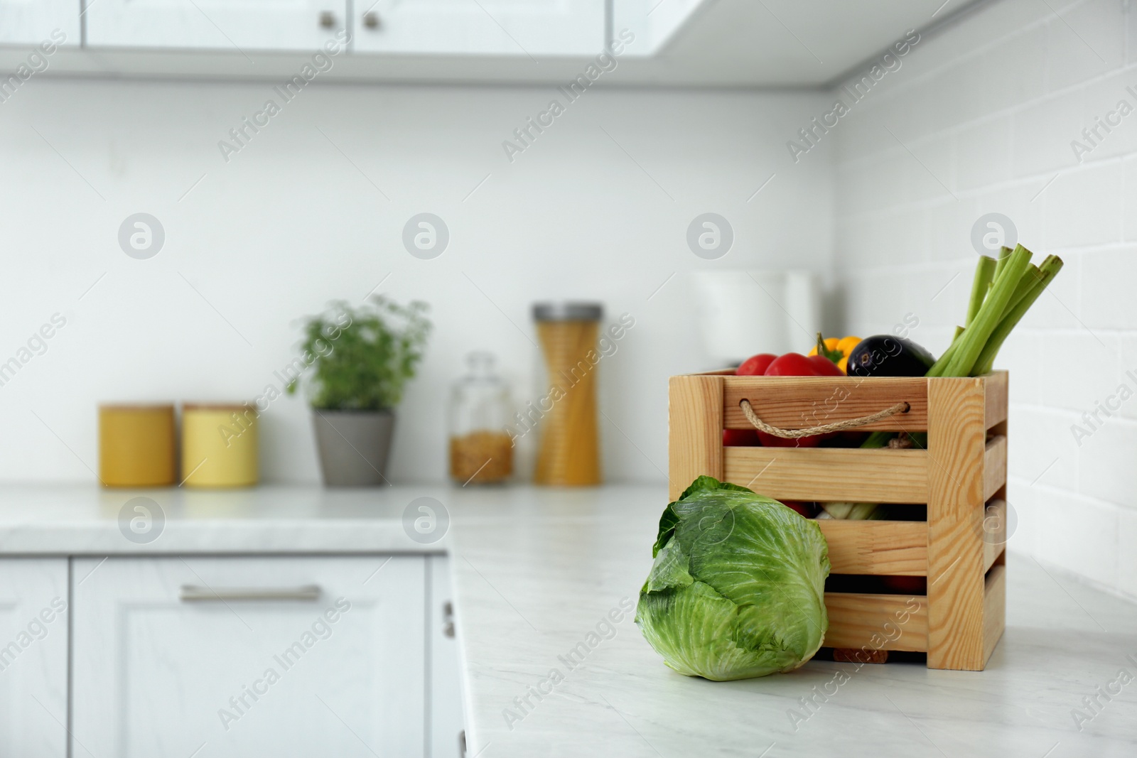 Photo of Different fresh vegetables on countertop in modern kitchen. Space for text