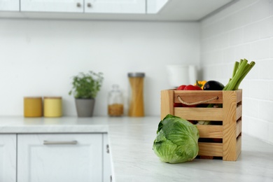 Photo of Different fresh vegetables on countertop in modern kitchen. Space for text