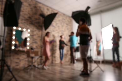 Blurred view of professional team working with model in photo studio