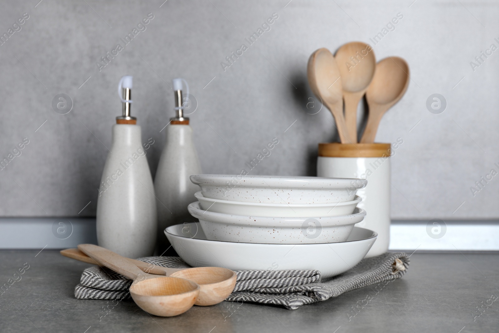 Photo of Set of different cooking utensils on grey countertop in kitchen