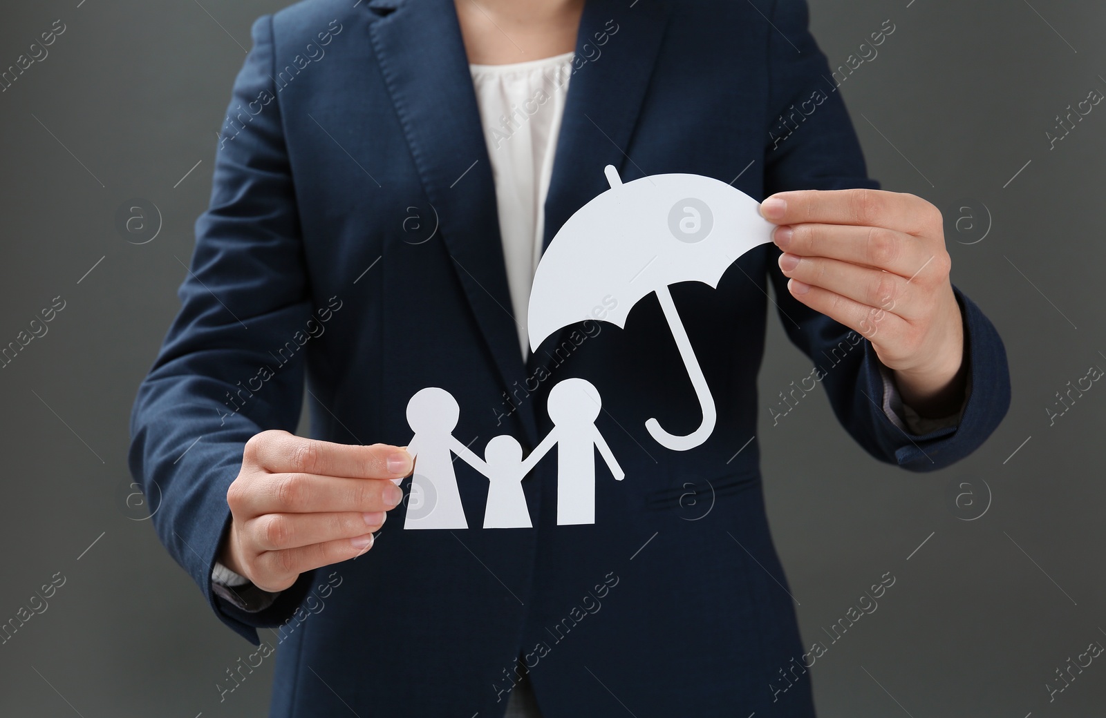 Photo of Woman holding cutout paper family and umbrella, closeup. Life insurance concept