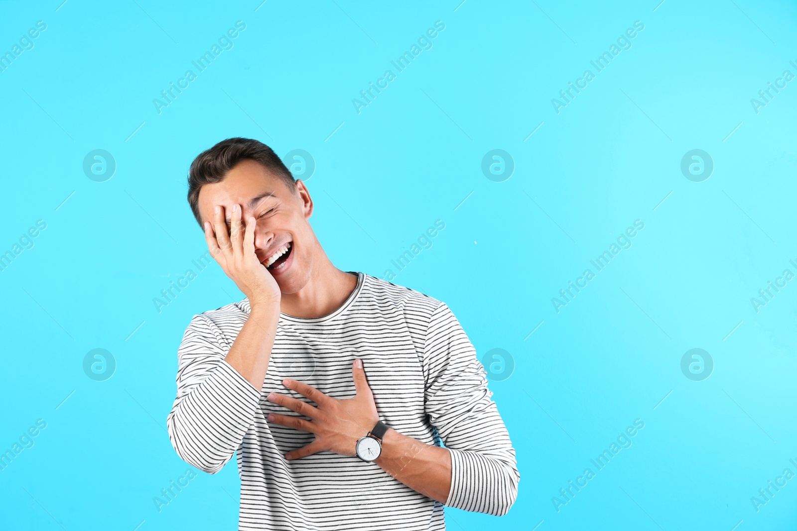 Photo of Portrait of handsome young man laughing on color background. Space for text