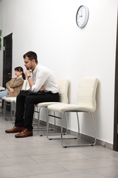 Man and woman waiting for job interview indoors