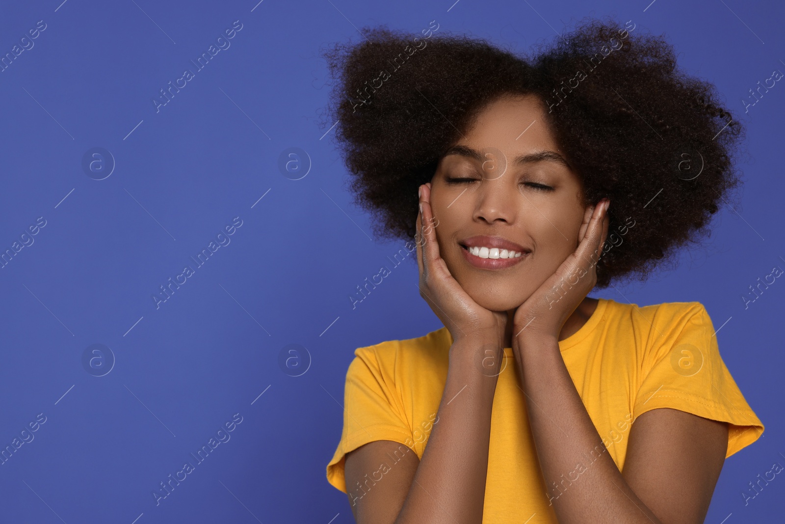 Photo of Portrait of smiling African American woman on purple background. Space for text