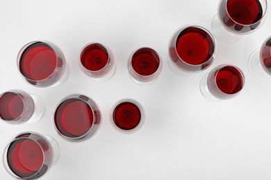 Glass of expensive red wine on light background, top view