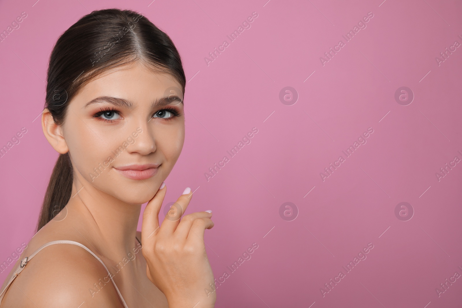 Photo of Portrait of pretty girl on pink background, space for text. Beautiful face with perfect smooth skin