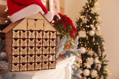 Photo of Wooden house shaped Advent calendar in room decorated for New Year