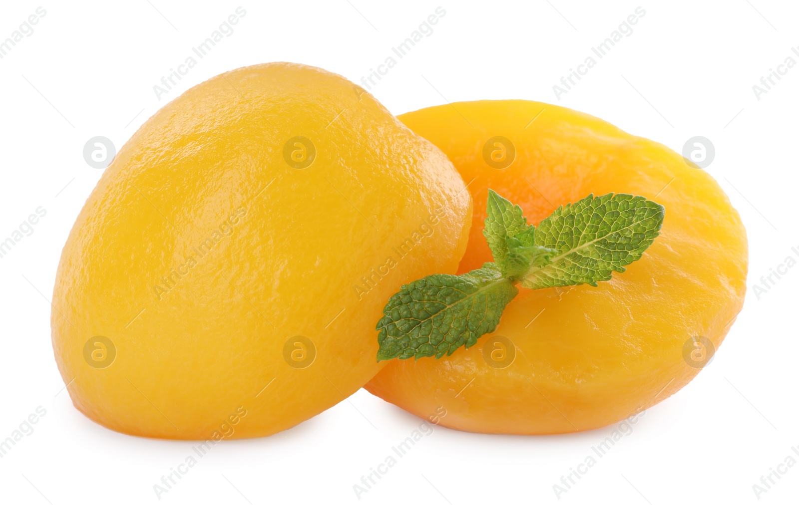 Photo of Sweet canned peach halves with mint isolated on white