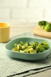 Photo of Pieces of boiled broccoli and squash on grey table, space for text. Child's food