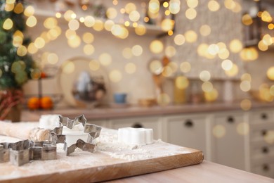 Photo of Cookie cutters on wooden table in kitchen, space for text