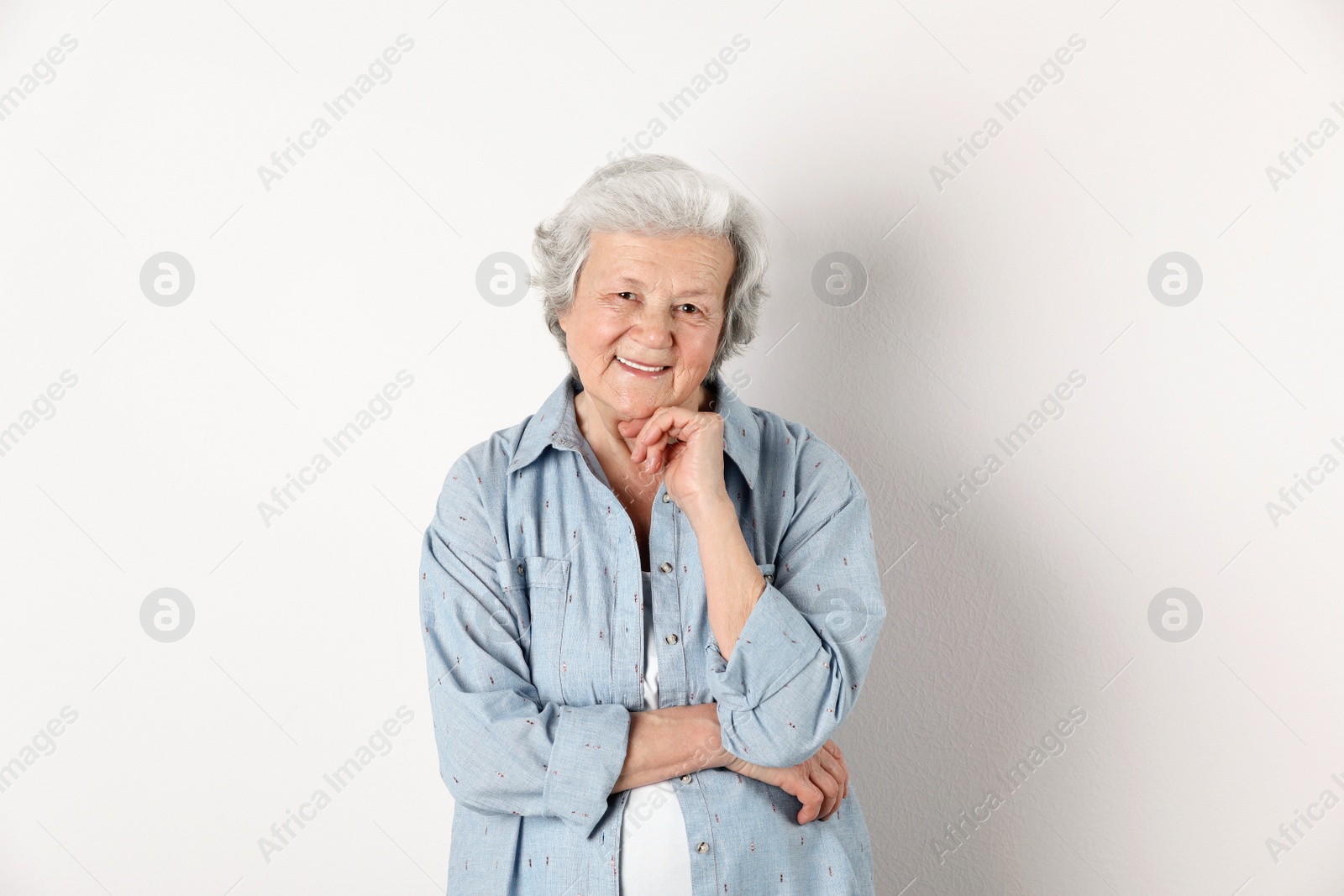 Photo of Portrait of grandmother in stylish clothes on light background