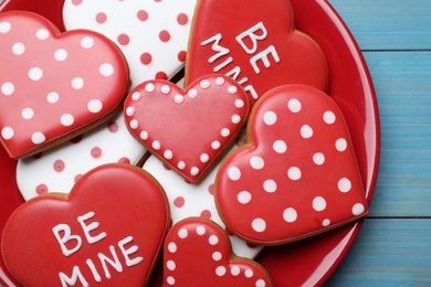 Decorated heart shaped cookies on blue wooden table, top view. Valentine's day treat