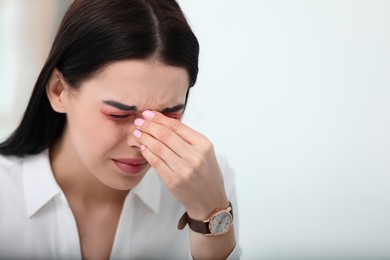 Tired woman with red eyes on white background, space for text