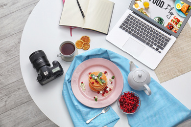 Photo of Flat lay composition with delicious pancakes, camera and laptop on white table. Food blog