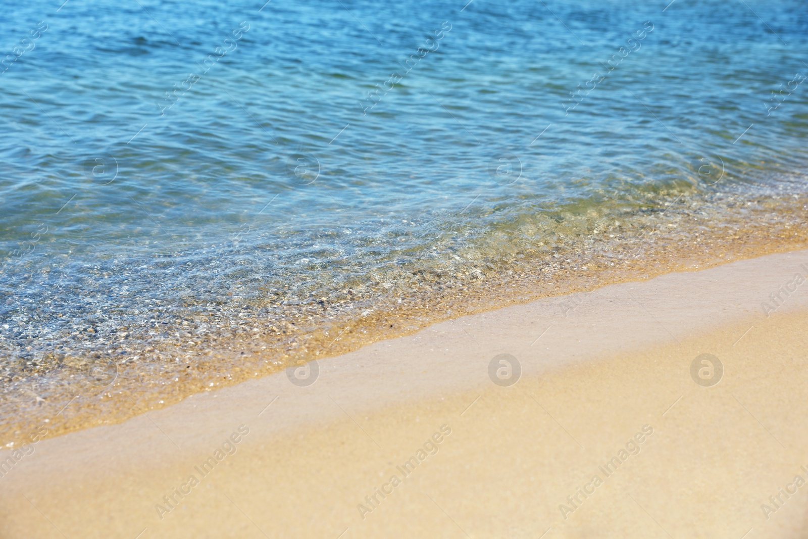 Photo of View of sea water and beach sand on sunny day