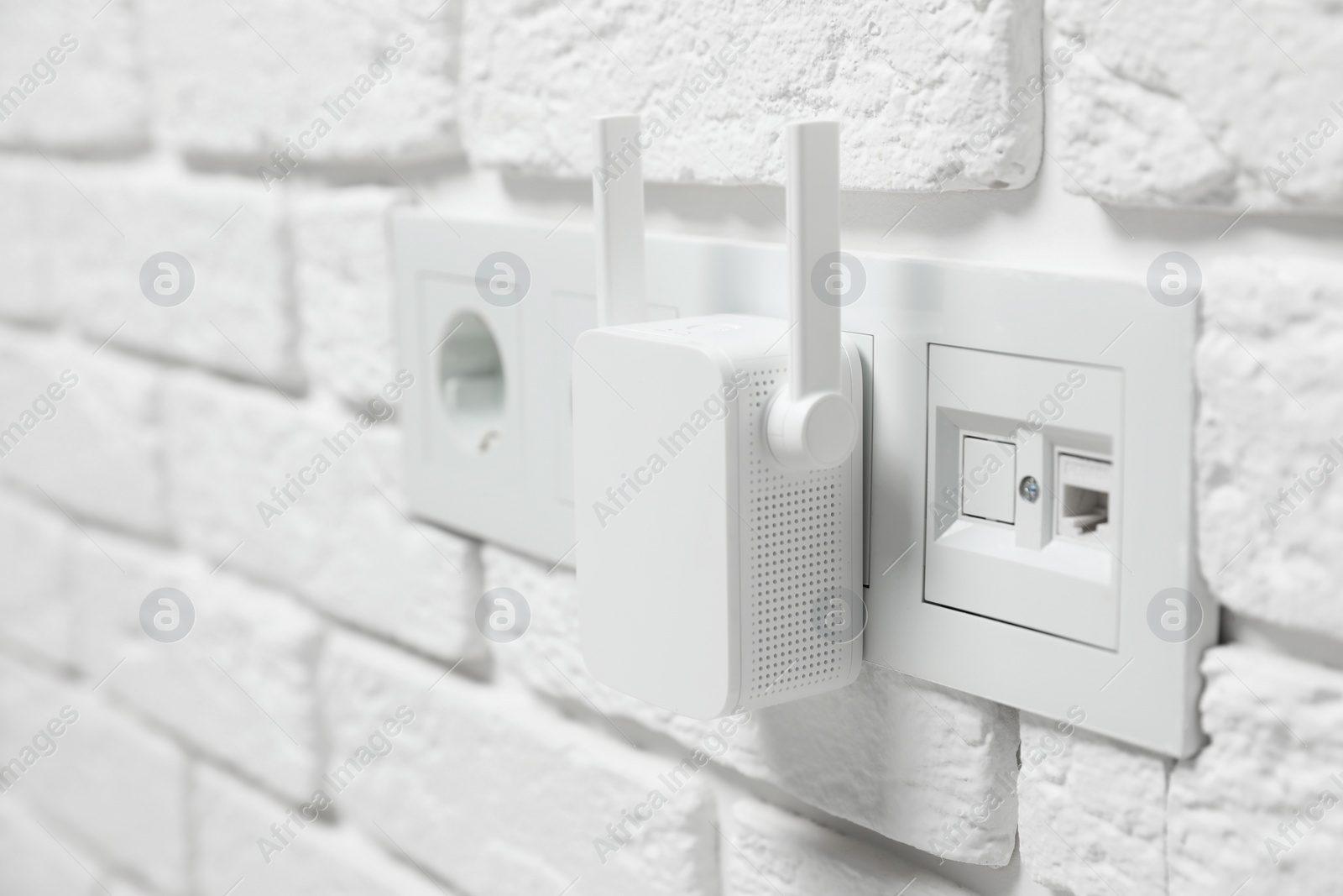 Photo of Wireless Wi-Fi repeater on white brick wall