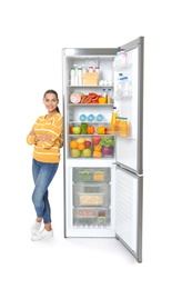 Photo of Young woman near open refrigerator on white background