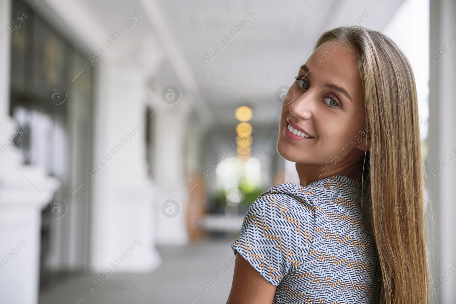 Photo of Beautiful young woman in stylish t-shirt indoors, space for text