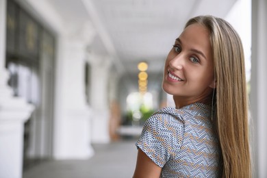 Beautiful young woman in stylish t-shirt indoors, space for text