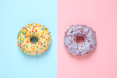 Photo of Delicious glazed donuts on color background, flat lay