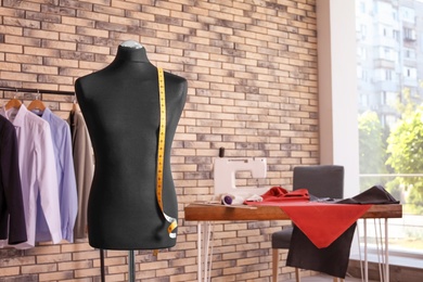 Photo of Mannequin with measuring tape in tailor studio