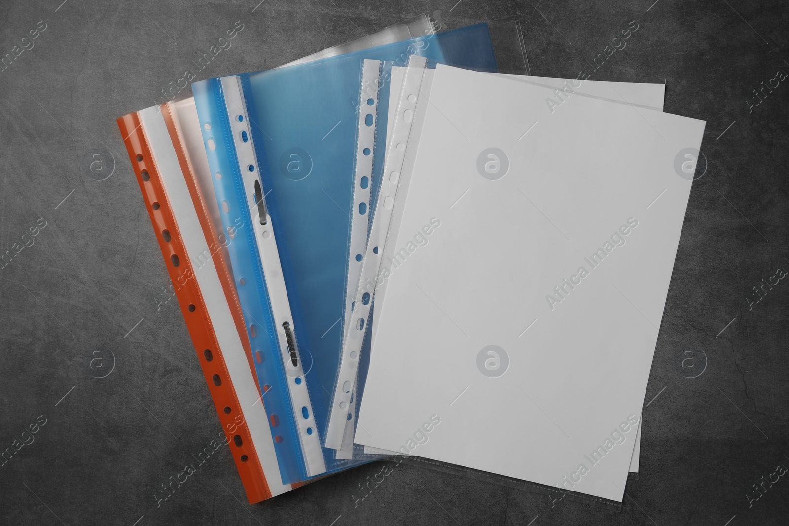 Photo of File folders with punched pockets on grey table, flat lay. Space for text