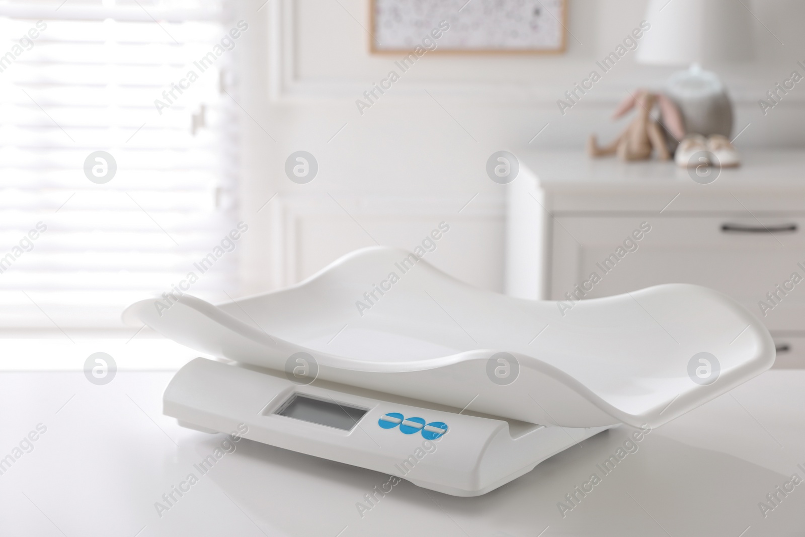 Photo of Modern digital baby scales on table in room