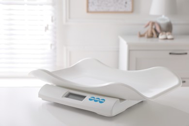 Modern digital baby scales on table in room