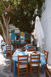 Photo of Beautiful outdoor cafe with wooden furniture on sunny day