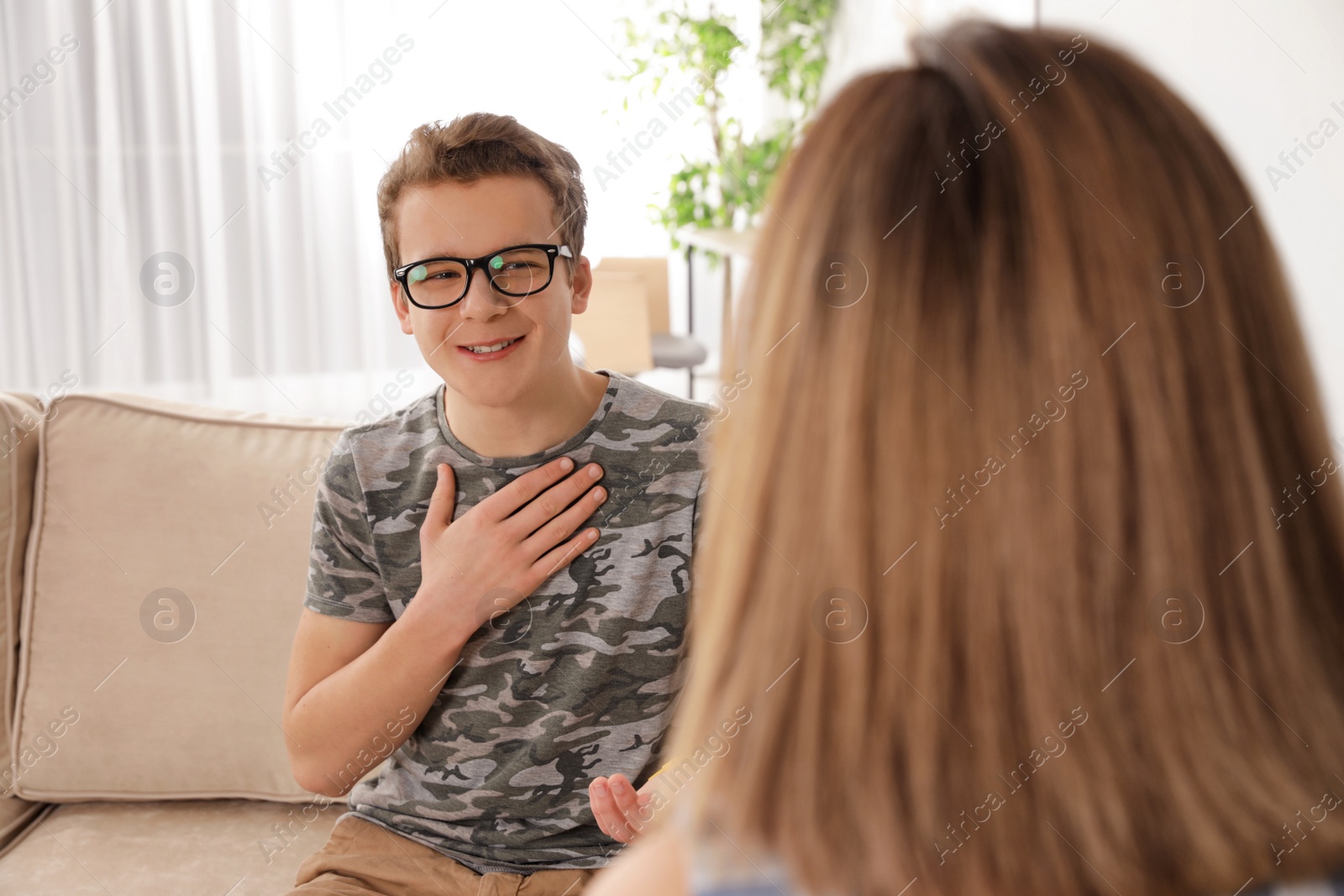 Photo of Mother talking with her teenager son at home