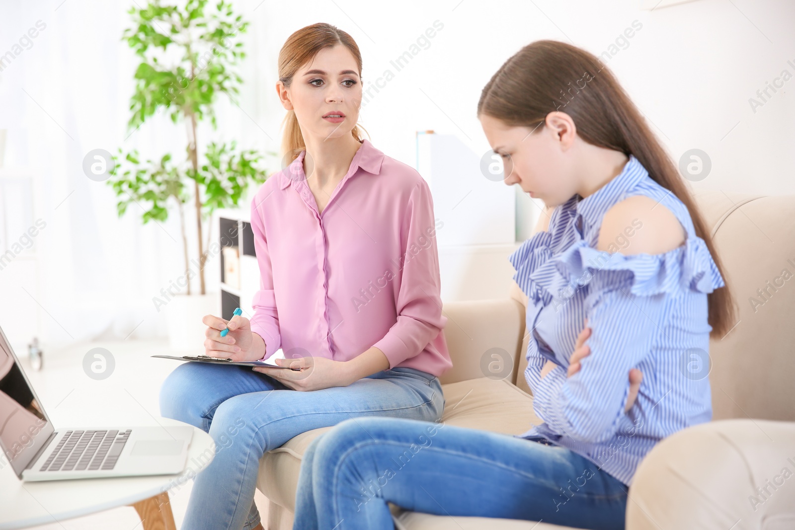 Photo of Female psychologist working with teenager girl in office