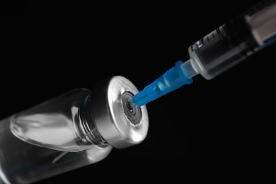 Vial and syringe on black background. Vaccination and immunization