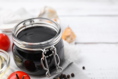 Photo of Organic balsamic vinegar and cooking ingredients on white table, closeup. Space for text