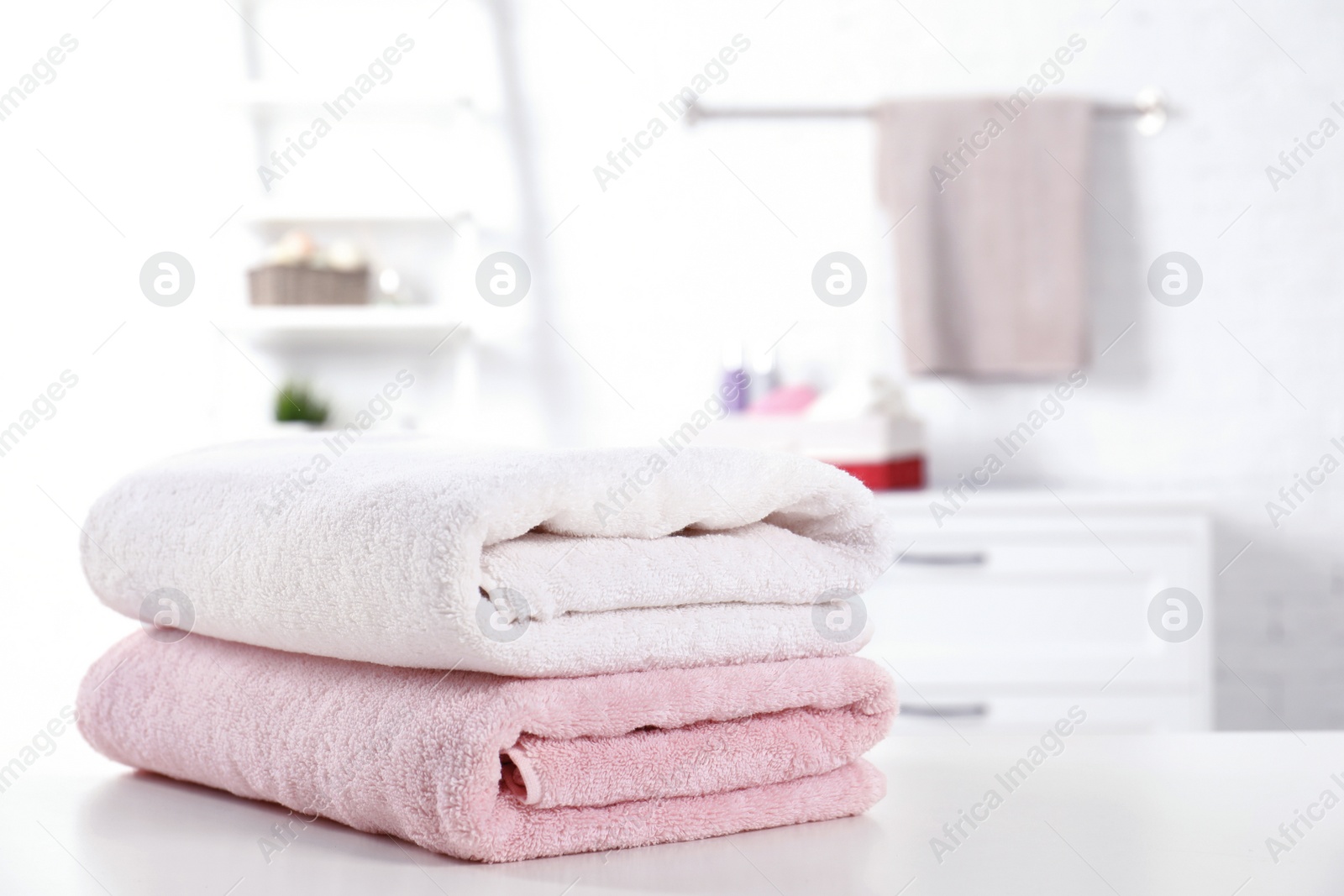 Photo of Stack of fresh towels on table in bathroom. Space for text