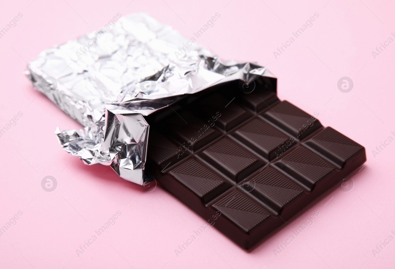 Photo of One tasty chocolate bar on pink background