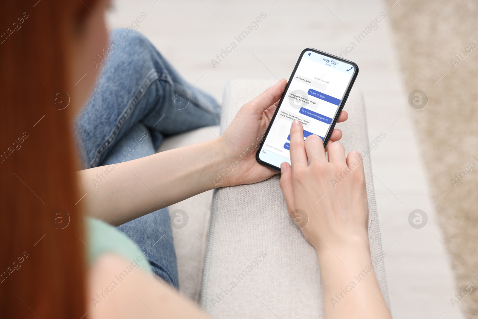 Image of Woman texting via mobile phone indoors, closeup. Device screen with messages