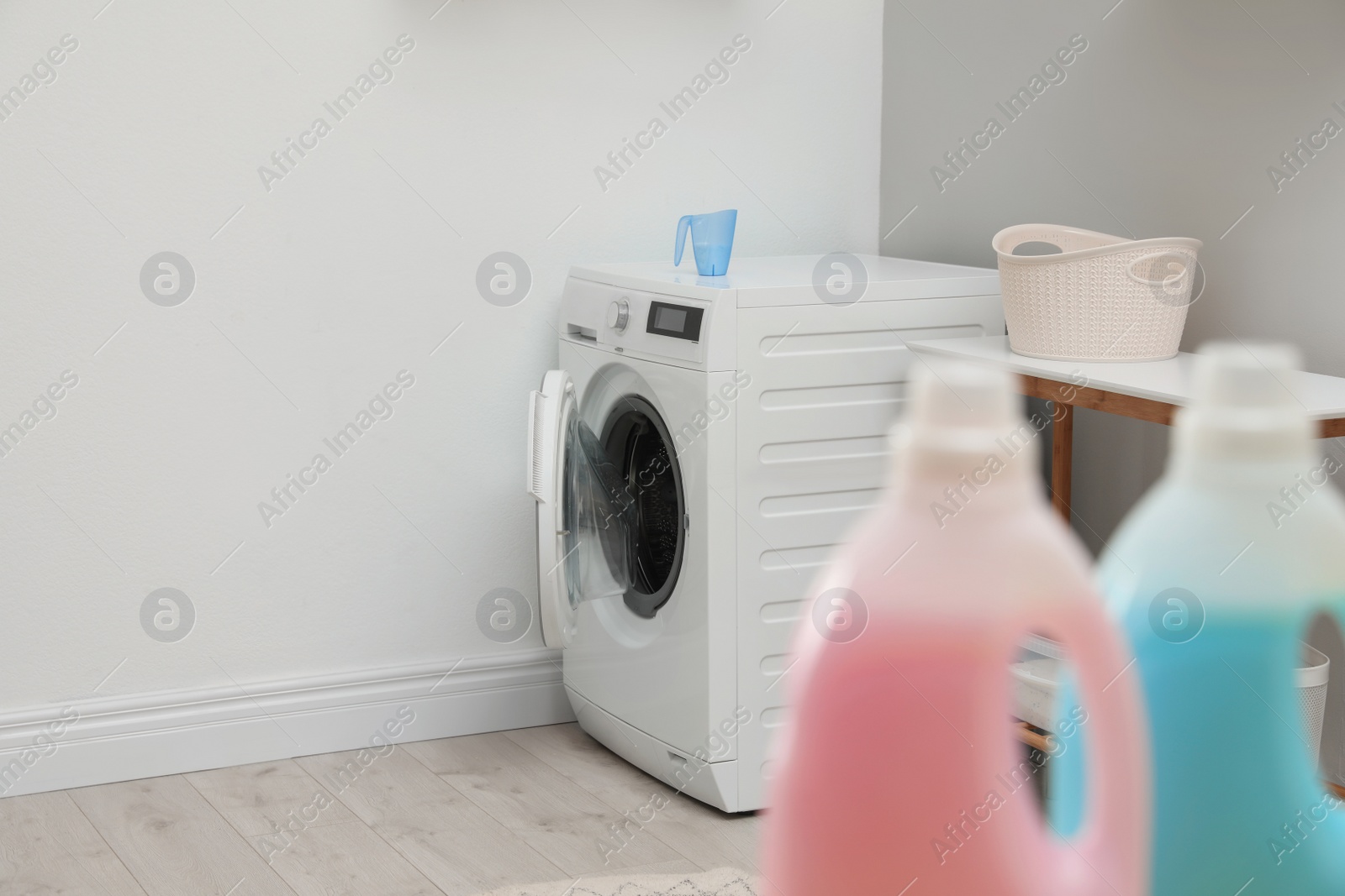 Photo of Modern washing machine in light laundry room. Space for design