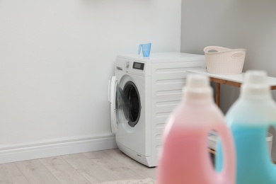 Photo of Modern washing machine in light laundry room. Space for design