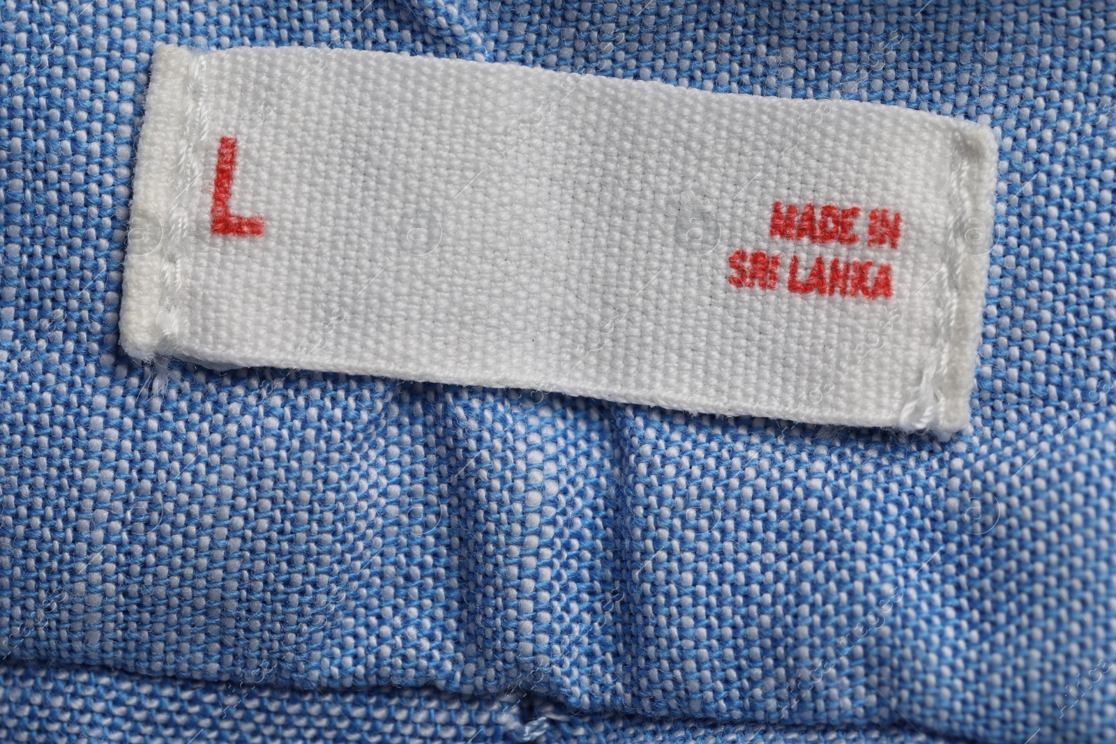 Photo of Clothing label on light blue garment, top view