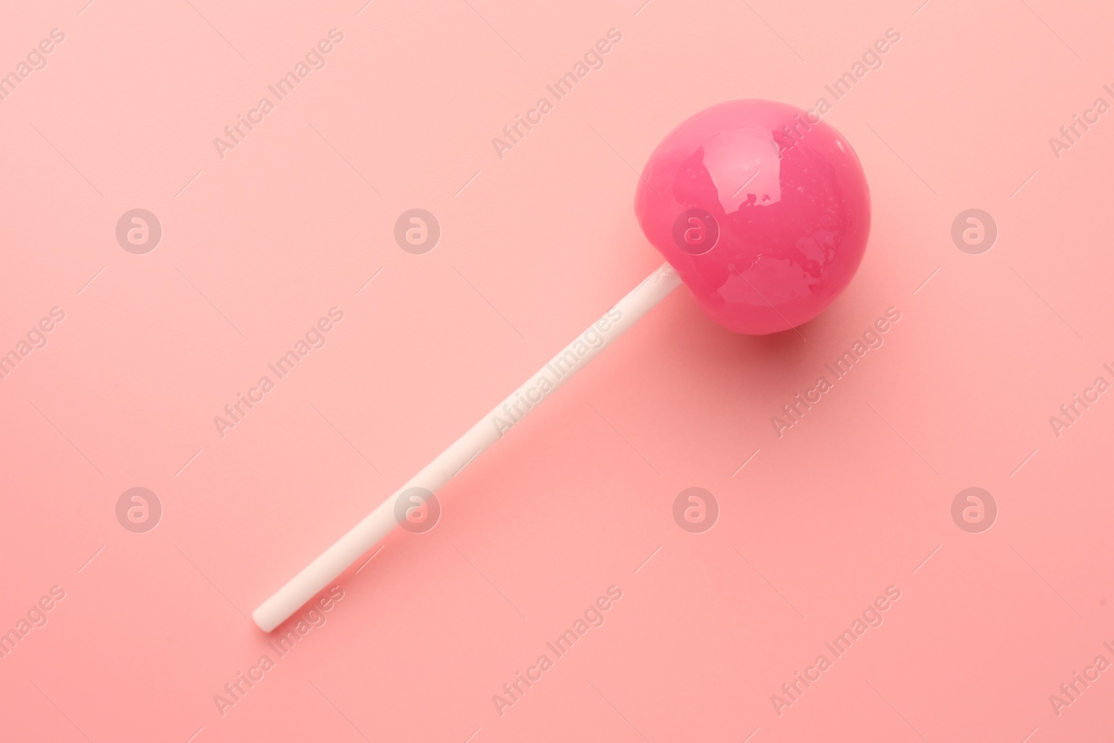 Photo of Tasty lollipop on pink background, top view