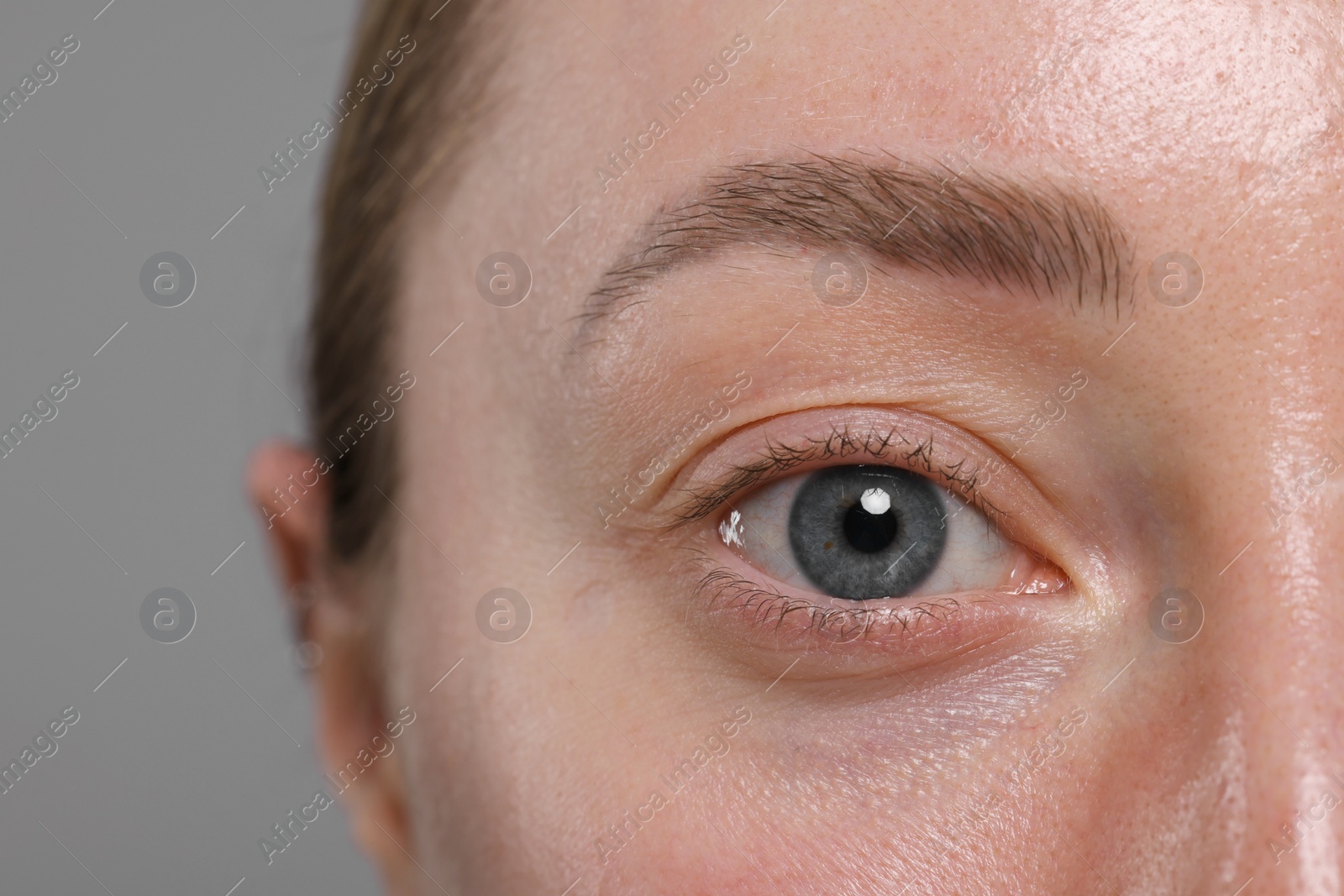 Photo of Closeup view of woman with beautiful eyes on grey background